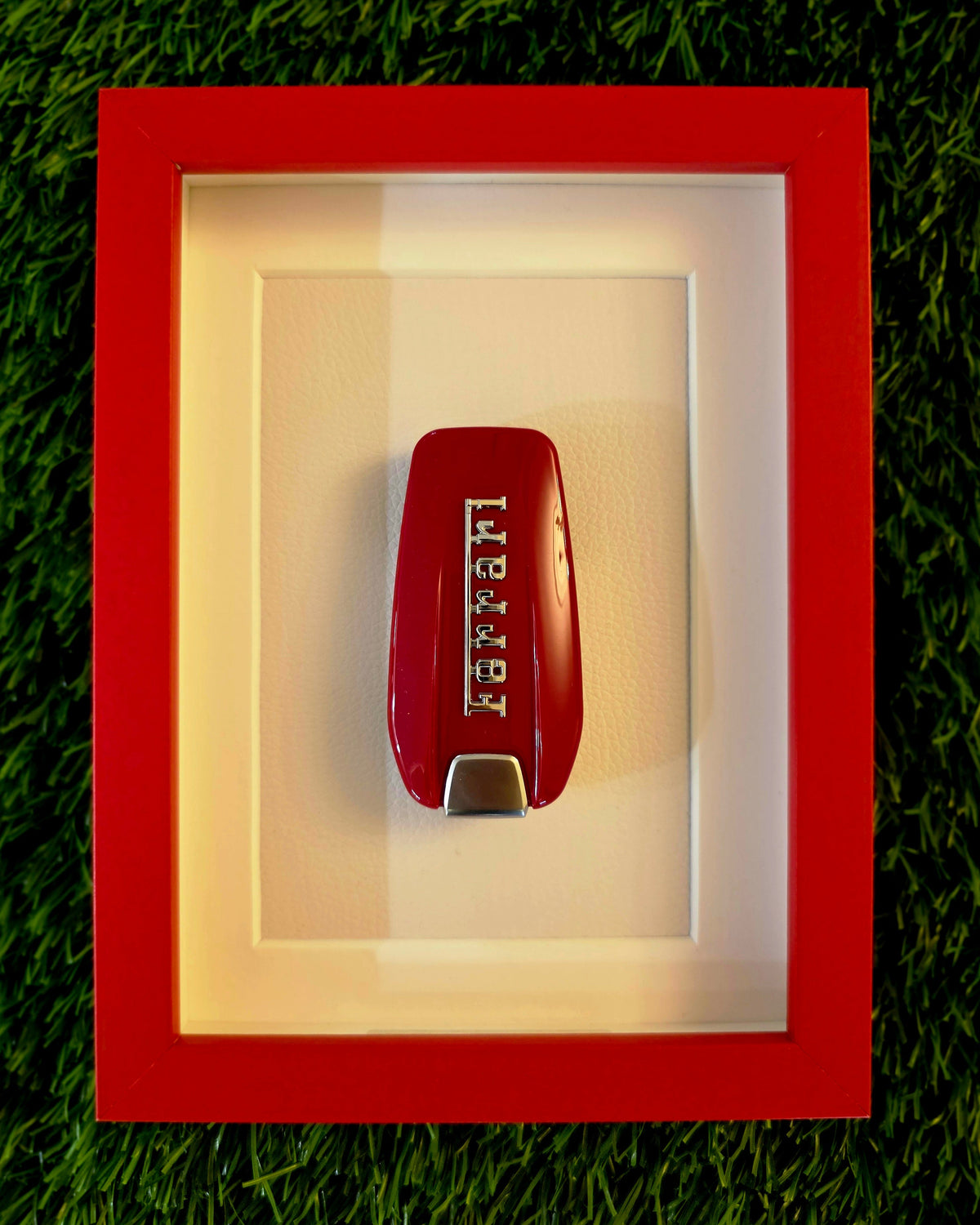 Red keychain with 'Levi's' logo in a red frame on a grass background