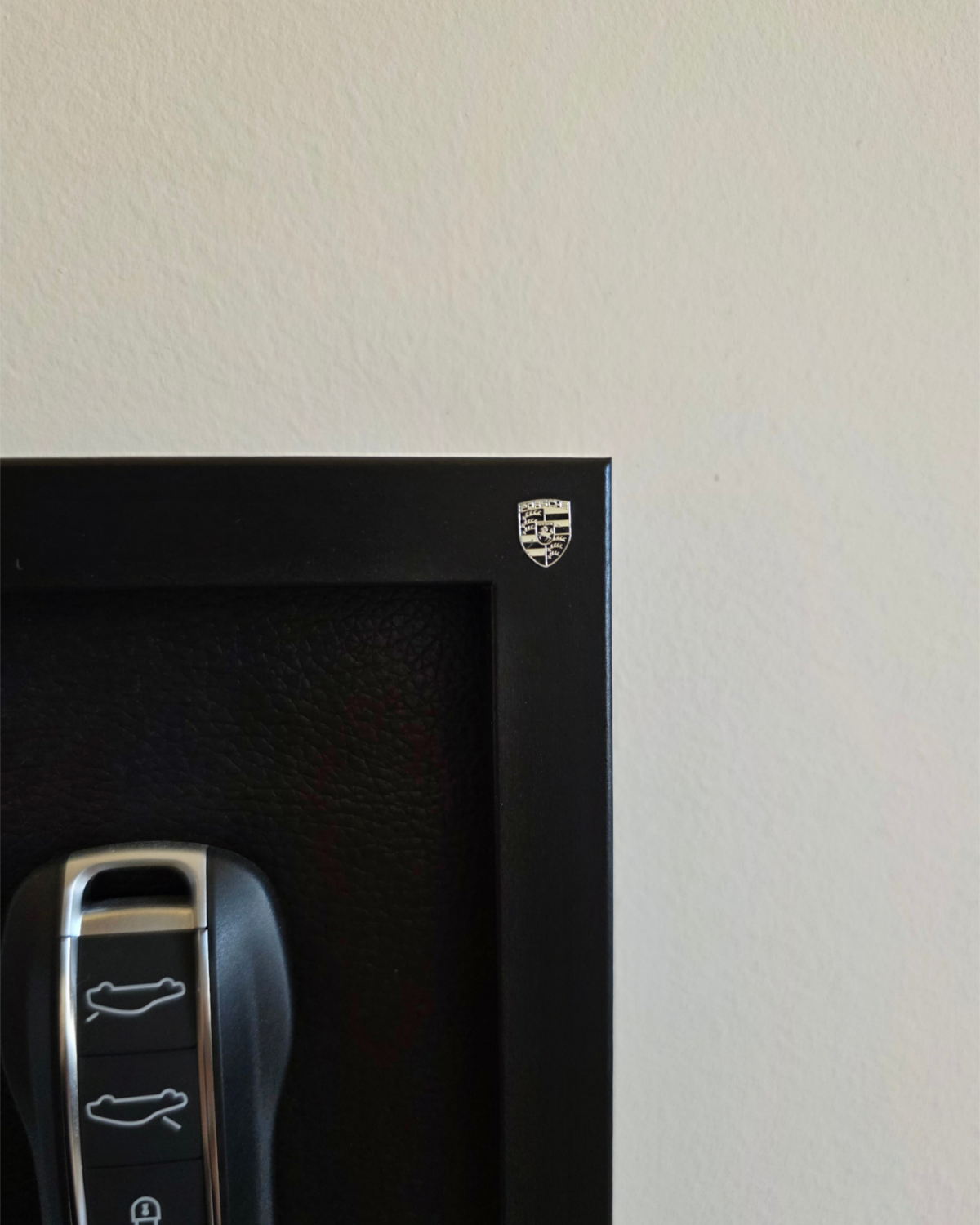 Black safe with Porsche logo and car key fob on a light gray background