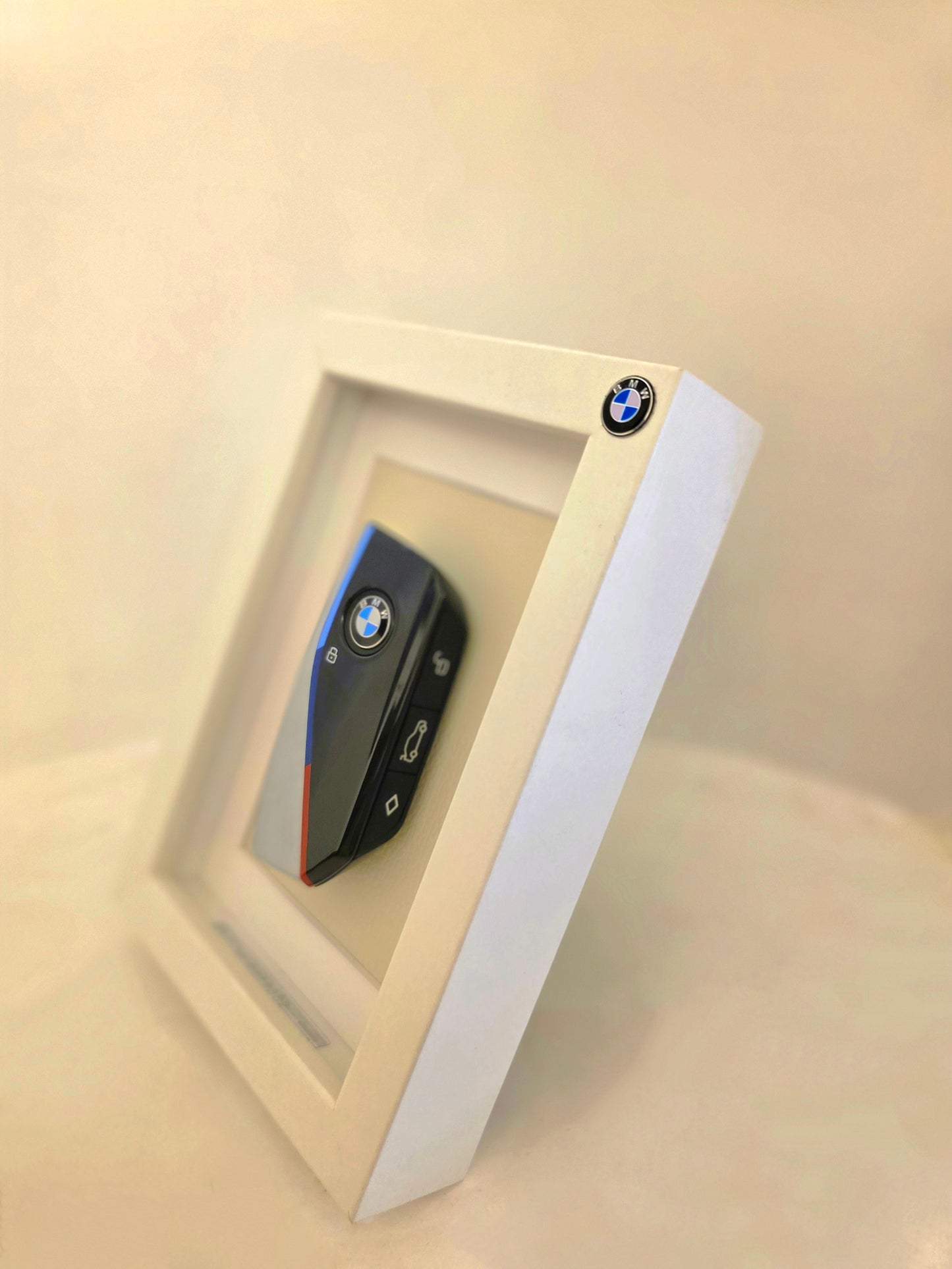 BMW key fob in a decorative frame on a beige background