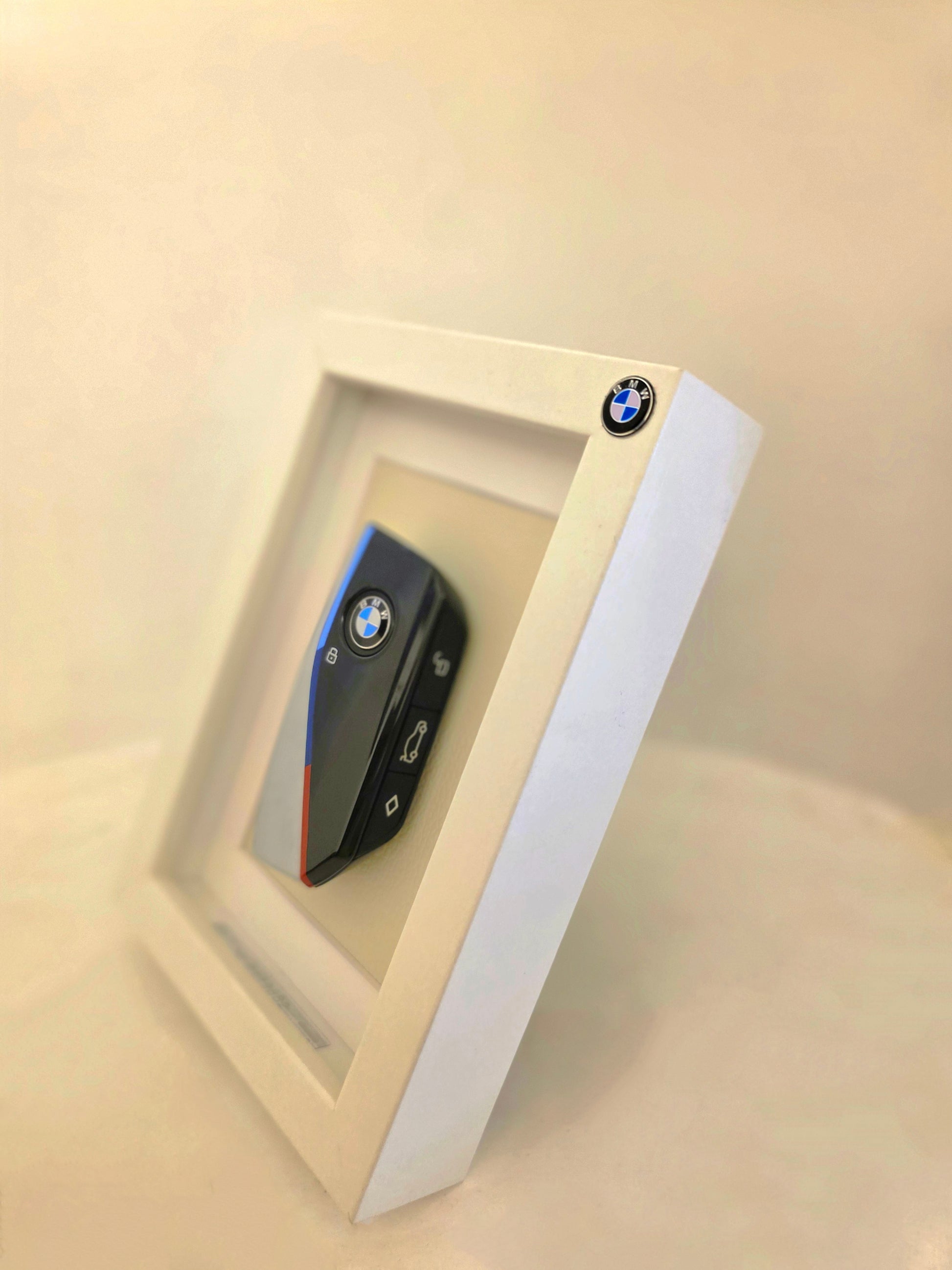 BMW key fob in a decorative frame on a beige background