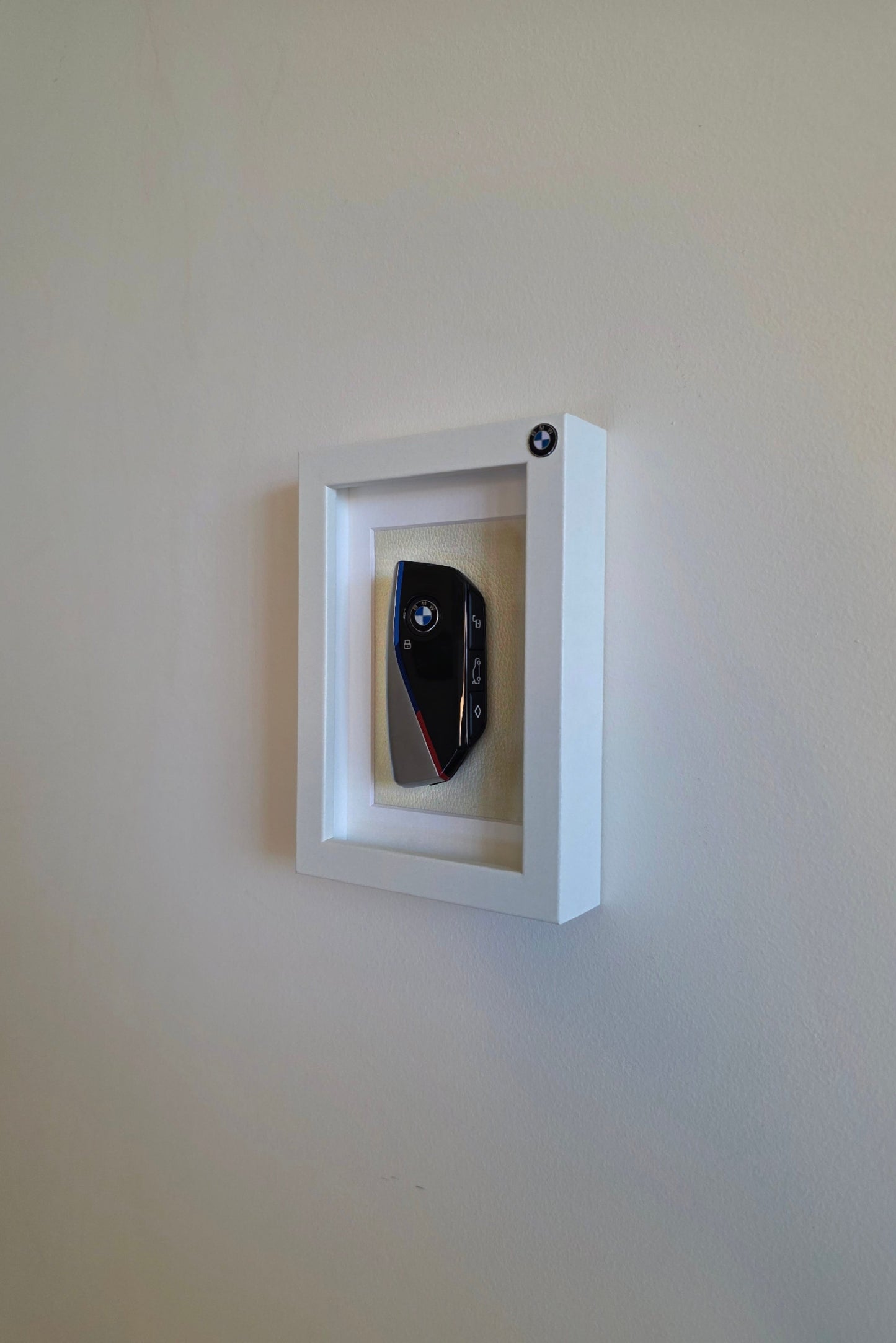 Framed object with a reflective surface on a plain wall